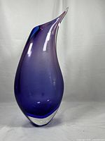 Front view of elongated tear-drop vase showing purple interior and clear outer layer