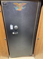 Front exterior of black Cannon safe with eagle decal and floor-mounted design