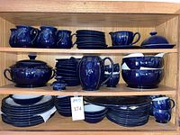 Full shelf view showing complete set of blue Baroque pattern dinnerware and serveware