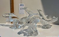 Set of 4 clear glass dolphin figurines arrayed side-by-side, all by Lenox