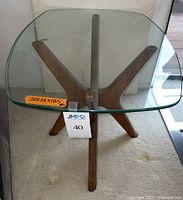 Top-down view showing rectangular glass top with bow edge and the underlying walnut base.