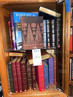 Top and bottom shelves showing mixed leather-bound volumes and decorative hardcover