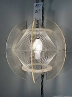 Pendant light hanging by chain from ceiling, showing full view of Lucite rings and nylon string pattern