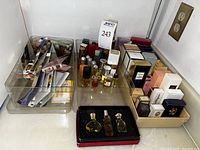 Top view of three clear trays containing boxed mini perfume bottles, loose mini bottles and sample vials scattered