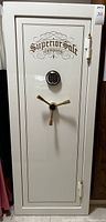 Front view of tall cream-colored safe with gold trim, three-spoke handle and built-in lock.