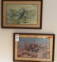 Two Western themed framed wall art pieces hung on wall, showing overall condition and size.