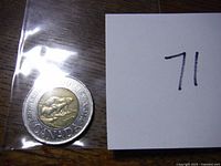 Photo of the reverse side of a 2000 Canadian two-dollar coin showing two polar bears and 'KNOWLEDGE CANADA' inscription.