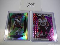 Two Chase Young football rookie cards in plastic protectors on a white background with a card showing lot number 255.