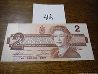 Front side of 1986 Canadian $2 bill showing portrait of Queen Elizabeth II and denomination.