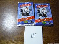 Front view of two sealed 2006-07 Upper Deck Victory hockey card booster packs on a table.