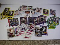 Full view of the collection spread out showing a variety of hockey cards with players in maroon and white team uniforms, green-bordered cards, yellow bordered cards and various other designs.
