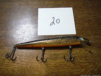 Photo of the Smithwick Rattlin Rogue jerkbait lure on a wooden surface with a card labeled '20' for identification.