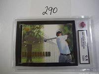 Front view of the 2001 Upper Deck Tiger Woods rookie card in graded KSA 9.5 case showing Tiger Woods swinging with a green grid background and gold foil lettering.
