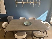 Overview of dining table and chairs under chandelier