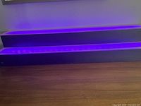 Two black rectangular LED bar lights emitting purple light, designed for liquor display illumination