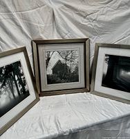 Photo of all three framed black and white photographs displayed together showing the different scenes and frames.