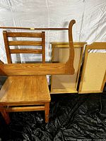 Wooden chair, teak tea cart, and two framed corkboards arranged against a white backdrop with black fabric on floor.