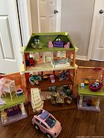 Assembled three-story house with roof, figures and scattered furniture