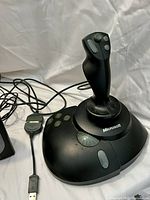 Photo of black Microsoft joystick with multiple buttons and wired connection