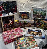 Full grouping of assorted jigsaw puzzles, showing box front illustrations and piece counts.