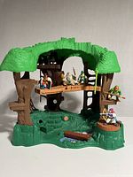 Front view of the Fisher Price Great Adventures Robin Hood treehouse playset with six character figures arranged on and around it.