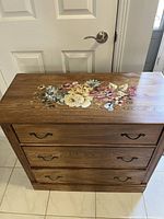 Top view of dresser showing floral decal on the refinished wood surface.