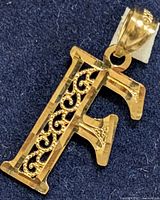 Close-up front photo of the 10K yellow gold letter 'F' pendant showing filigree detail.