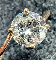 Close-up top-down view of the round brilliant lab diamond solitaire set in yellow gold showing facets and prongs