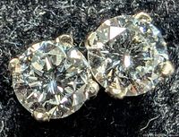 Close-up image of two round lab-created diamonds set in white gold prong earrings.