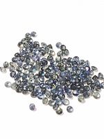 Close-up of numerous small loose cabochon cut sapphires in varying shades of blue and gray, showing their shape, size, and color.