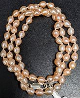 Full length of the freshwater pearl necklace showing the shape, size, and color of the pearls and the silver clasp.