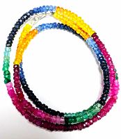 Necklace layered in an oval shape showing multi-colored gemstones in blue, black, green, yellow, pink, and red tones
