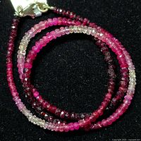 Coiled view of the ruby bead necklace showing rich color gradation and silver clasp.