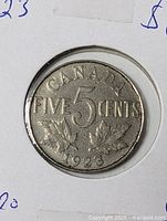 Reverse of 1923 Canadian 5 cent coin in holder