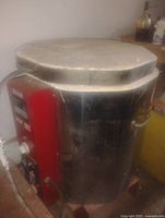 Full view of stainless steel kiln with red control panel and hinged lid