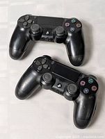 Both black DualShock 4 controllers top view