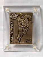 Front view of bronze hockey card in acrylic holder showing Gordie Howe relief