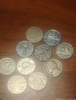 All ten coins laid out showing obverse and reverse designs for identification