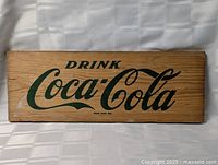 Full view of wooden Coca-Cola sign board