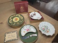 Photo of all three porcelain dishes showing the Royal Crown Derby butter dish with spreader in original box, Aynsley Pembroke floral dish, and Royal Grafton Highland Art shell-shaped dish in box