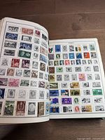 Open pages showing Australian postage stamps in various designs and colors, some featuring historical figures and events.