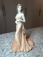Full view of the Coalport Age of Elegance Summer Saunter porcelain figurine on a countertop showing the flowing gown and figure posture.