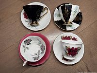 Top view of four English cups and saucers with floral and black designs