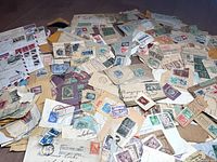 Wide view of a large assortment of old envelopes and papers with a variety of used international postage stamps affixed