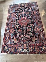 Full view of rug laid flat on wood floor showing overall pattern and color