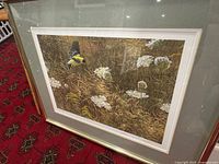 Full view of framed print leaning on patterned carpet floor