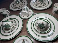 Four place settings arranged with deep dinner plates, salad plates, cups and saucers