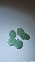 Six natural mint green oval cabochon kyanite gemstones, approx. 8x6mm, total 10.28 carats.