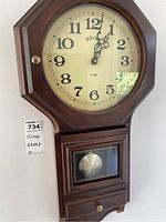 Full view of the Belova wooden wall clock showing the face and lower pendulum section.