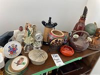 Group of figures, vases, containers, and decorative items on a wooden table captured from front